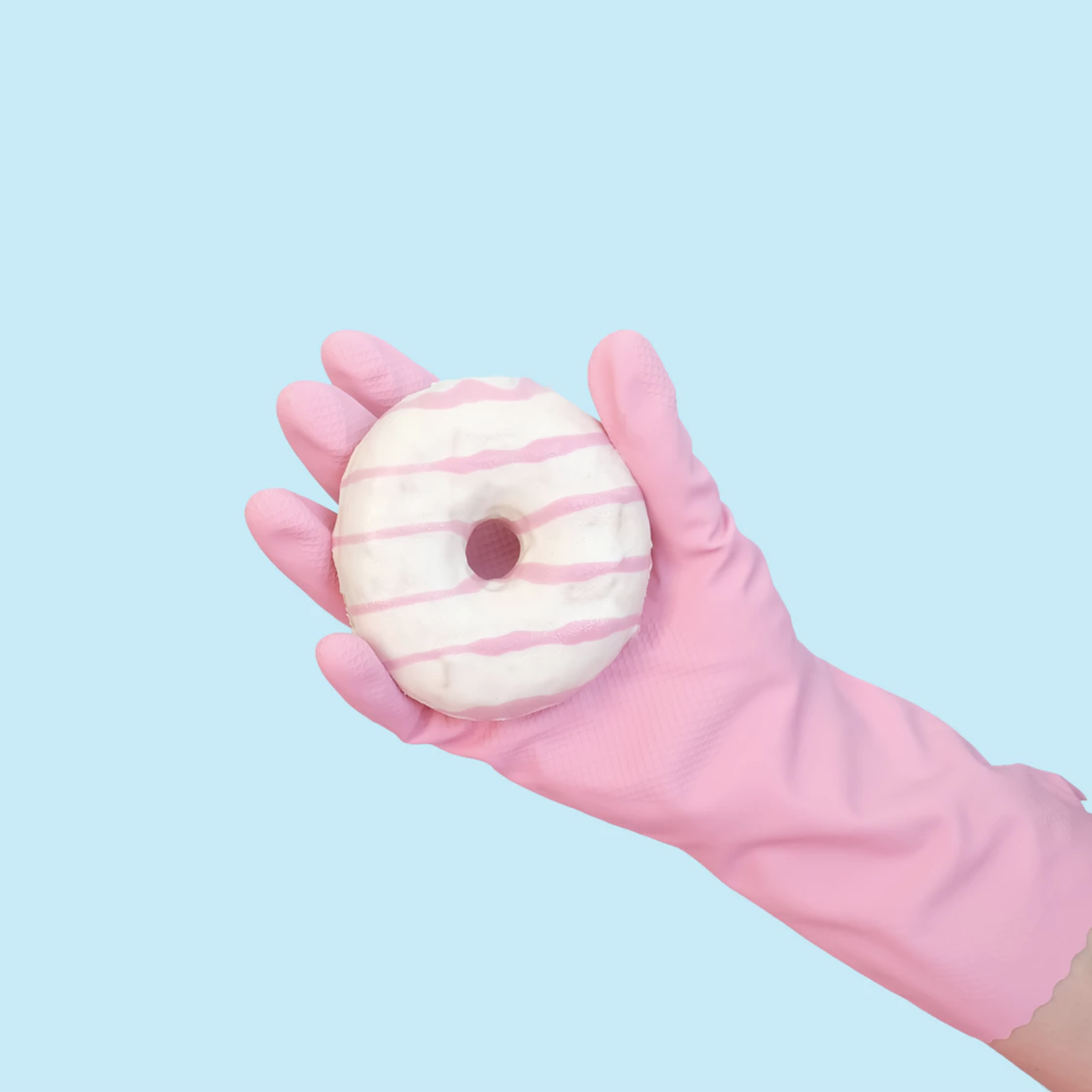 gloved hand holding a donut